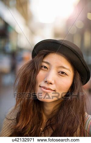 Stock Image - Portrait of mid-adult woman with hat. Fotosearch