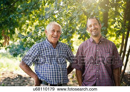 Stock Photo - "Portrait of senior man and son in vegetable garden, Tuscany, Italy". Fotosearch