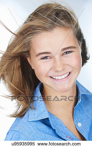 Stock Photography - Portrait of smiling teenage girl with hair blowing. Fotosearch