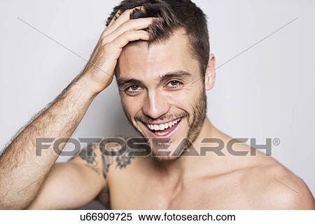 Portrait of smiling young man with tattoo on shoulder View Large Photo Image Stock Photography - Portrait of smiling young man with tattoo on shoulder. Fotosearch