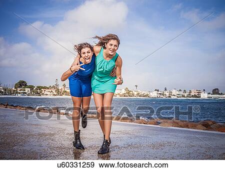 Portrait of two young women friends fooling around on promenade View Large Photo Image Stock Photo - Portrait of two young women friends fooling around on promenade. Fotosearch