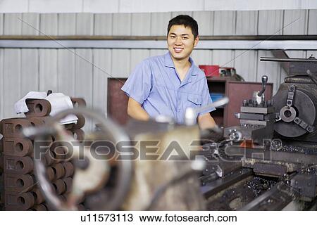 "Portrait of worker next to machinery in crane factory, Jiangsu Province, China" View Large Photo Image Stock Image - "Portrait of worker next to machinery in crane factory, Jiangsu Province, China". Fotosearch
