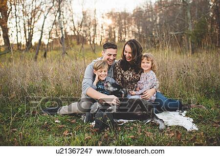 "Portrait of young couple with son, daughter and dog in field" View Large Photo Image Stock Photo - "Portrait of young couple with son, daughter and dog in field". Fotosearch