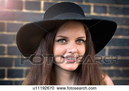 Portrait of young woman with hat and nose ring stud View Large Photo Image Stock Image - Portrait of young woman with hat and nose ring stud. Fotosearch