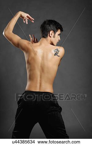 Picture - Rear studio shot of young man poised in martial arts pose. Fotosearch