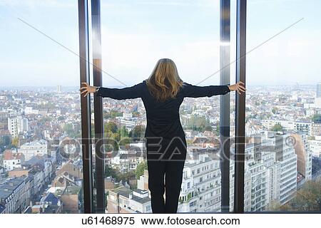 "Rear view of businesswoman looking from office window at Brussels cityscape, Belgium" View Large Photo Image Stock Photography - "Rear view of businesswoman looking from office window at Brussels cityscape, Belgium". Fotosearch