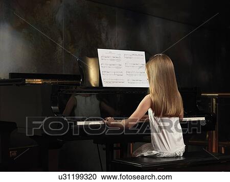 Rear view of girl playing piano on stage View Large Photo Image Stock Image - Rear view of girl playing piano on stage. Fotosearch