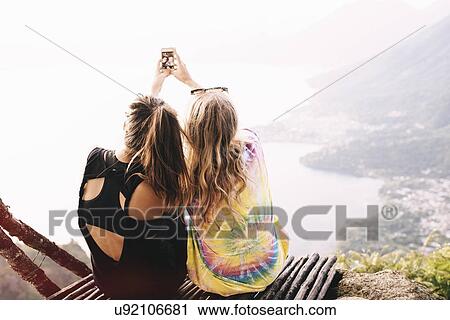 "Rear view of two female friends taking smartphone selfie at Lake Atitlan, Guatemala" View Large Photo Image Stock Image - "Rear view of two female friends taking smartphone selfie at Lake Atitlan, Guatemala". Fotosearch