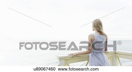 "Rear view of young woman looking out to sea from balcony, Miami Beach, Florida, USA" View Large Photo Image Stock Image - "Rear view of young woman looking out to sea from balcony, Miami Beach, Florida, USA". Fotosearch