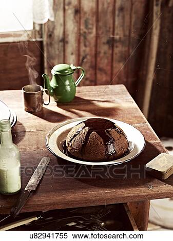 Stock Photography - Rustic table with dish of steamed treacle pudding. Fotosearch
