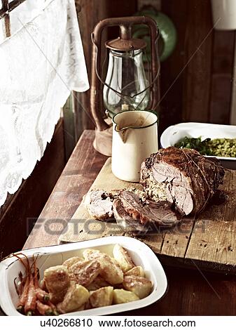 Stock Image - Rustic table with roasted goose on chopping board and roasted vegetables. Fotosearch