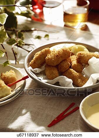 Stock Photo - Salted cod croquettes with lemon and beer. Fotosearch