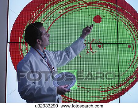 Stock Image - Scientist studying graphical display of silicon wafer on screens. Fotosearch
