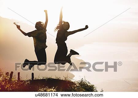 "Silhouetted view of young woman and man jumping mid air at sunset above Lake Atitlan, Guatemala" View Large Photo Image Picture - "Silhouetted view of young woman and man jumping mid air at sunset above Lake Atitlan, Guatemala". Fotosearch