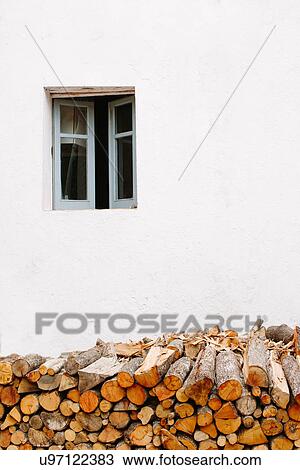 Stock Image - "Stack of logs outside house, Sardinia, Italy". Fotosearch