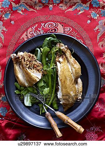 Stock Photo - Still life of Beggars Chicken with lotus leaf and greens. Fotosearch