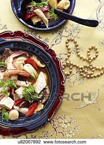 Stock Image - "Still life of Buddha Jump Over Wall with squid, prawns, bok choi, tofu and coriander garnish". Fotosearch