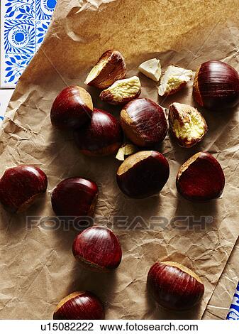 Stock Image - Still life of chestnuts on brown paper. Fotosearch