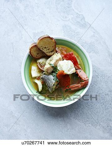 Stock Image - Still life with a bowl of bouillabaisse and bread. Fotosearch