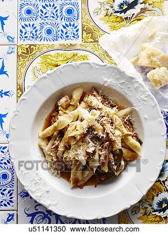 Stock Image - Still life with bowl of Italian rabbit gargenelli and parmesan. Fotosearch