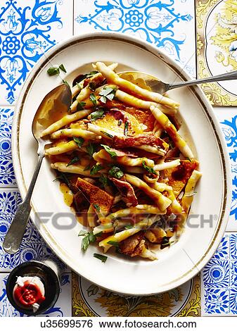 Stock Photograph - Still life with dish of Italian pumpkin and bacon strozzapetti. Fotosearch
