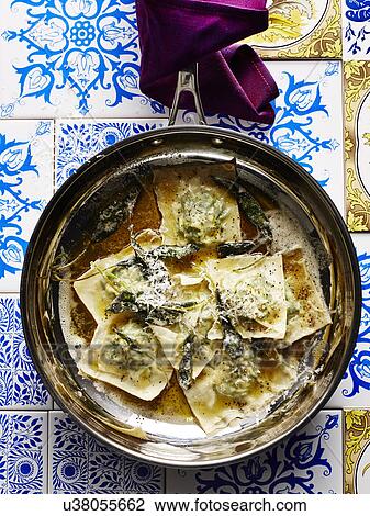 Stock Image - Still life with pan of Italian stinging nettle tortellini and parmesan. Fotosearch
