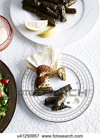 Still life with plate of slow cooked lamb in vine leaves View Large Photo Image Stock Photo - Still life with plate of slow cooked lamb in vine leaves. Fotosearch