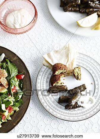 Stock Photo - "Still life with vine leaves, yogurt and Egyptian flatbread". Fotosearch