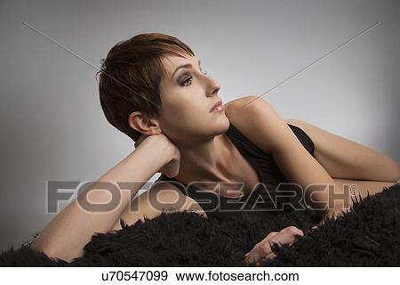 Studio portrait of bored woman lying on black rug View Large Photo Image Stock Photo - Studio portrait of bored woman lying on black rug. Fotosearch