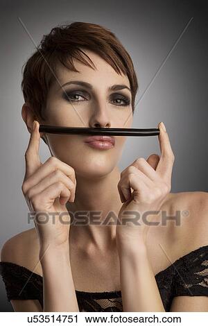 Studio portrait of woman holding up licorice stick as mustache View Large Photo Image Stock Image - Studio portrait of woman holding up licorice stick as mustache. Fotosearch