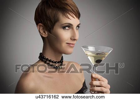 Studio portrait of woman looking sideways holding cocktail View Large Photo Image Stock Image - Studio portrait of woman looking sideways holding cocktail. Fotosearch