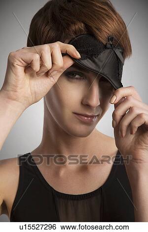 Studio portrait of woman peeking from black eye mask View Large Photo Image Stock Photograph - Studio portrait of woman peeking from black eye mask. Fotosearch