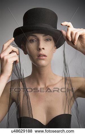 Studio portrait of woman wearing top hat and black veil View Large Photo Image Stock Photo - Studio portrait of woman wearing top hat and black veil. Fotosearch