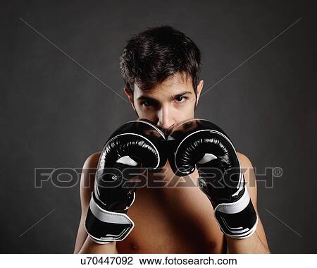 Studio portrait of young man with boxing gloves in front of face View Large Photo Image Stock Image - Studio portrait of young man with boxing gloves in front of face. Fotosearch