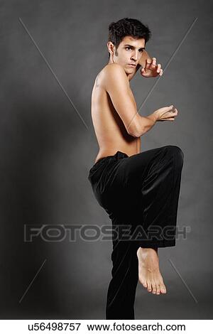 Stock Photo - Studio shot of young man poised in martial arts pose. Fotosearch