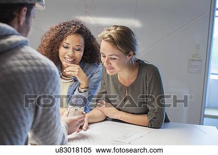 Three creative colleagues meeting at conference table View Large Photo Image Stock Photography - Three creative colleagues meeting at conference table. Fotosearch