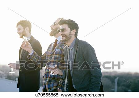Three men laughing and drinking at party View Large Photo Image Stock Photography - Three men laughing and drinking at party. Fotosearch
