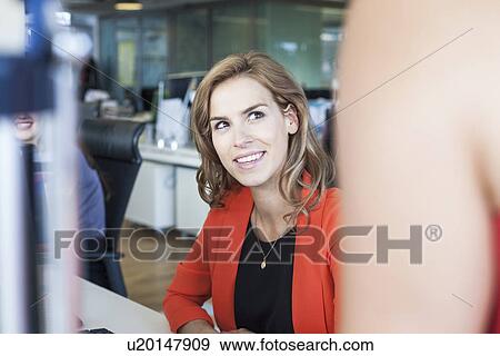 Two businesswomen having informal meeting at office desk View Large Photo Image Stock Photo - Two businesswomen having informal meeting at office desk. Fotosearch