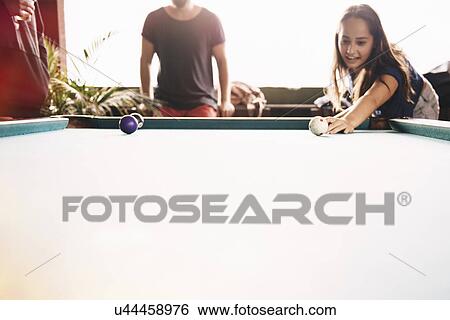 Stock Photograph - "Two young adult friends playing pool, Lake Atitlan, Guatemala". Fotosearch