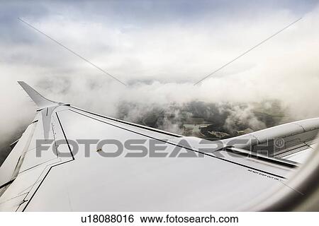 Stock Photograph - View of clouds and airplane wing above the Pyrenees. Fotosearch