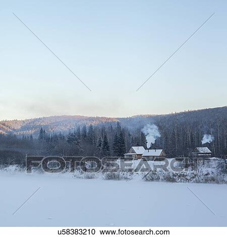 Stock Image - "View of distant houses and forest in snow covered landscape, Sarsy village, Sverdlovsk Oblast, Russia". Fotosearch