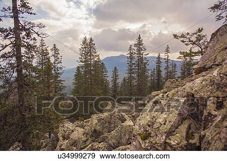 Stock Photo - "View of rocks, forest and distant mountains, Sarsy Village, Sverdlovsk Oblast, Russia". Fotosearch