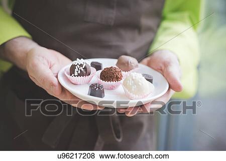 Waiter carrying plate of varying confectionery View Large Photo Image Stock Photo - Waiter carrying plate of varying confectionery. Fotosearch