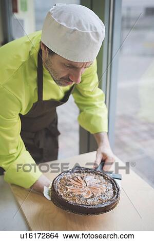 Picture - Waiter placing tart on table. Fotosearch