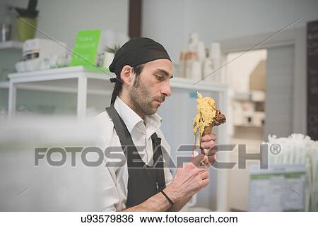 Waiter serving ice cream cone in cafe View Large Photo Image Stock Photograph - Waiter serving ice cream cone in cafe. Fotosearch