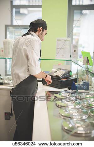 Waiter using cash register at cafe View Large Photo Image Picture - Waiter using cash register at cafe. Fotosearch