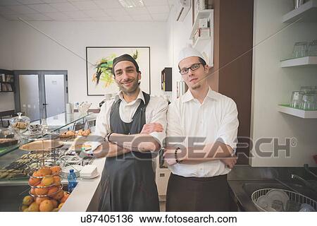 Stock Photograph - Waiters with arms crossed in cafe. Fotosearch