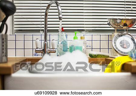 Water from kitchen faucet left running into sink View Large Photo Image Stock Photo - Water from kitchen faucet left running into sink. Fotosearch