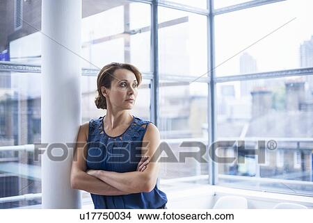 "Woman crossing arms, leaning against pillar" View Large Photo Image Picture - "Woman crossing arms, leaning against pillar". Fotosearch