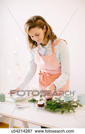 Woman decorating chocolate cupcakes View Large Photo Image Stock Photo - Woman decorating chocolate cupcakes. Fotosearch